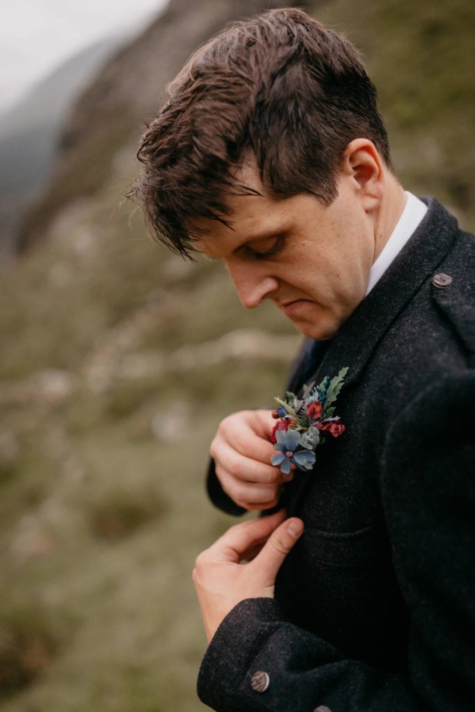 Groom getting changed in the outdoors for his elopement ceremony in the Scottish Corrie Fee, Cairngorms 