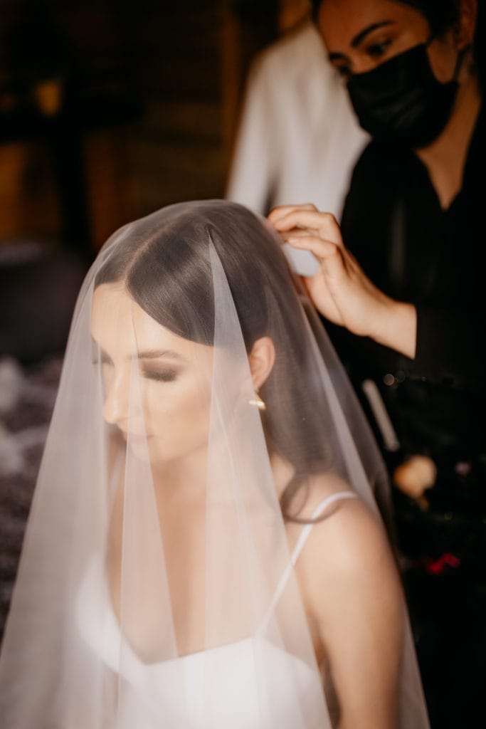 Bride putting on veil 