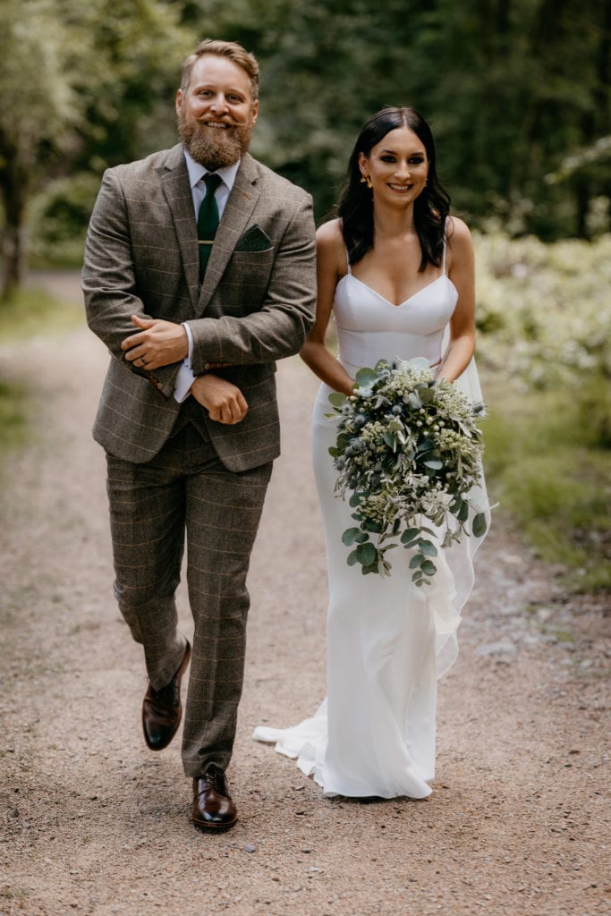 Bride and groom walking Glencoe Lochan