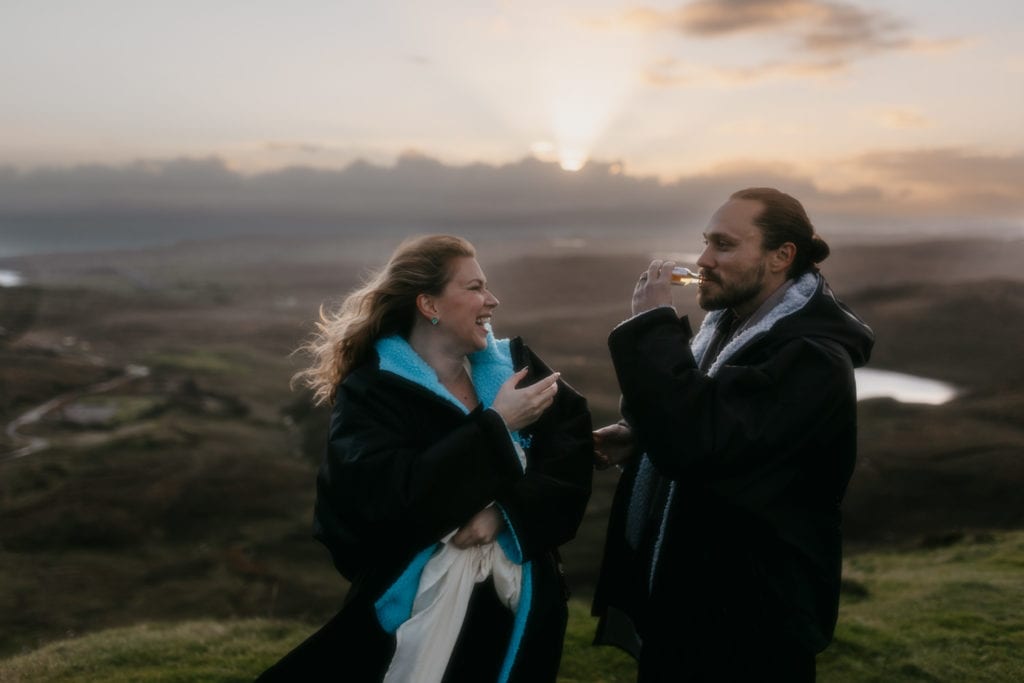 Couple on isle of skye drinking whisky wearing Dryrobes