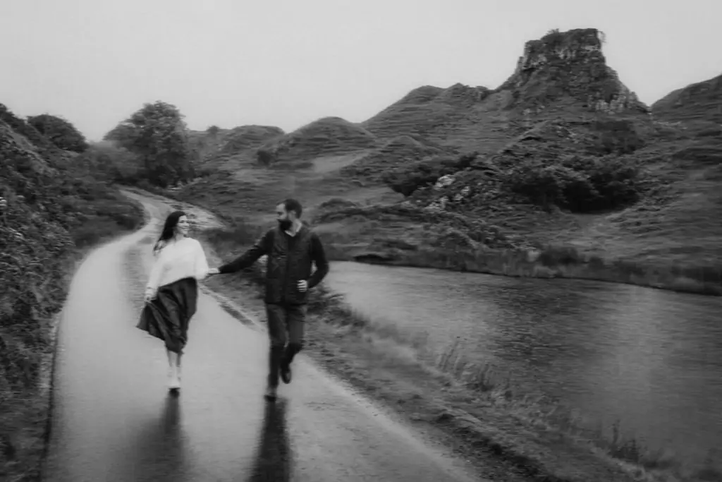 Couple running down the road at the Fairy Glen, Isle of Skye