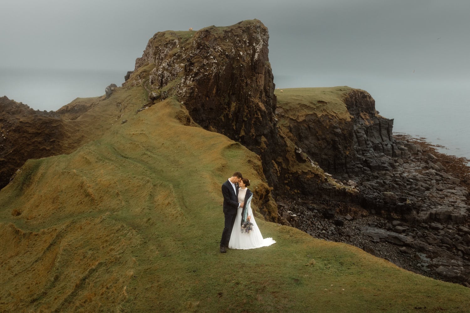 Eloping couple stand together at Brothers Point on the Isle of Skye. 