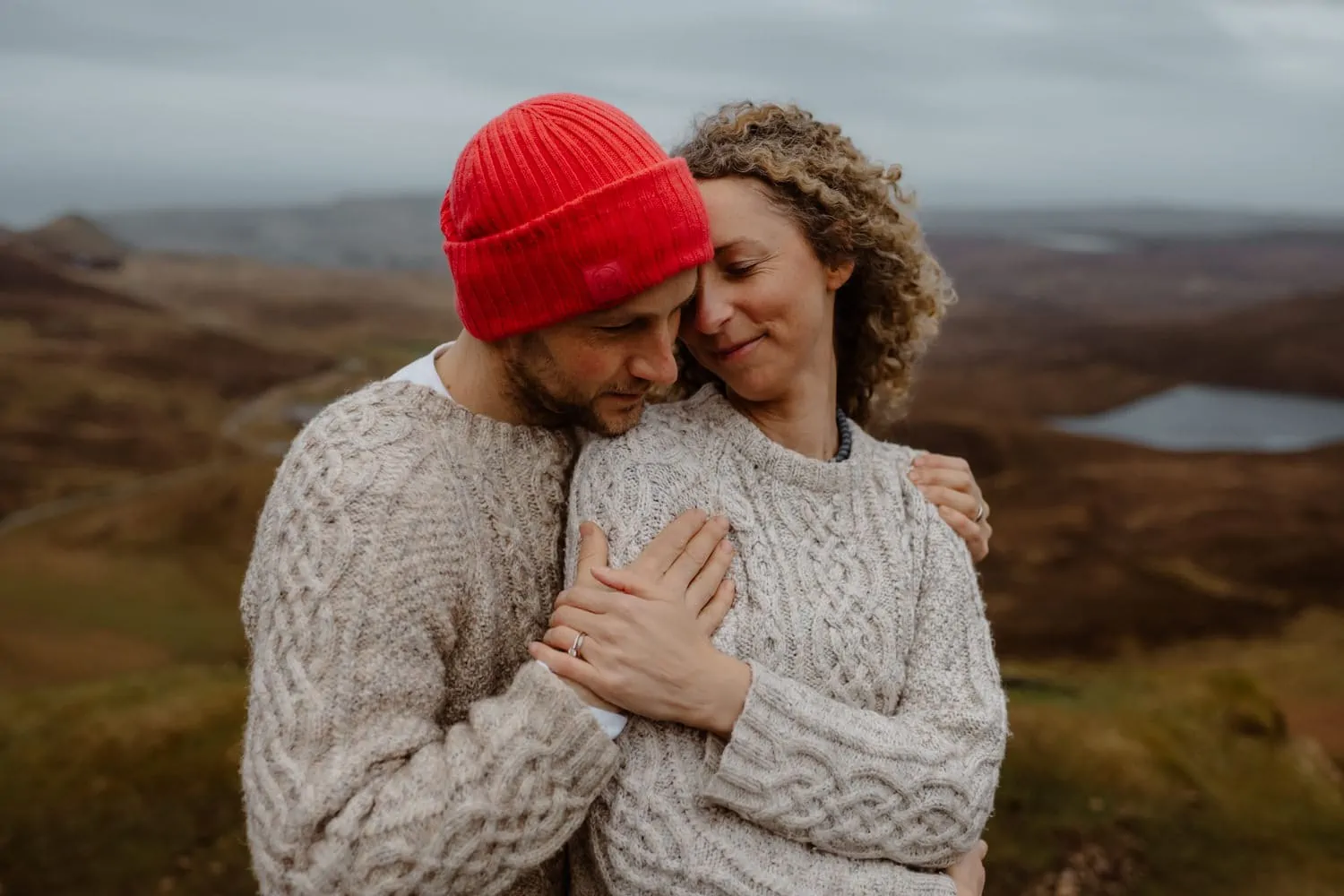 Oli and Steph embrace on the Quiraing, Isle of Skye in woollen jumpers, 