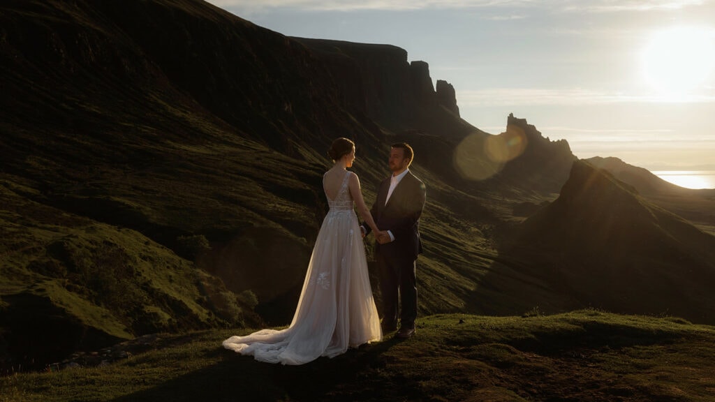 Celeste and Doug standing hand in hand in a majestic landscape of the Quiraing on the Isle of Skye