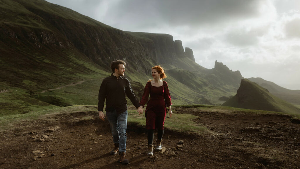 Ashley and Bobby walking hand in hand in the majestic landscape of the Quiraing on the Isle of Skye