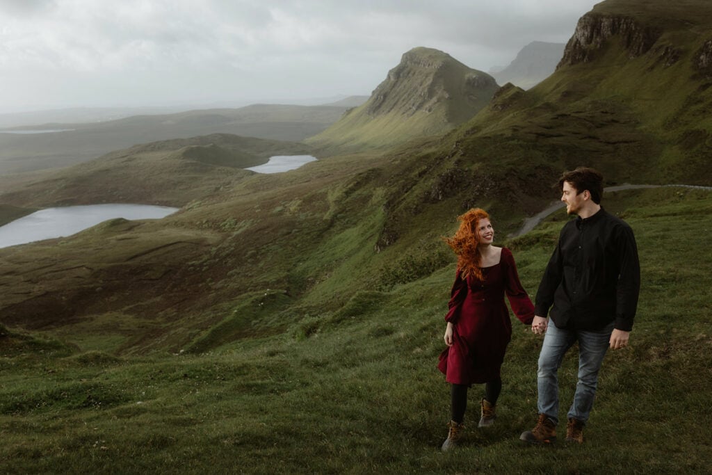 Ashley and Bobby standing hand in hand in the majestic landscape of the Quiraing on the Isle of Skye