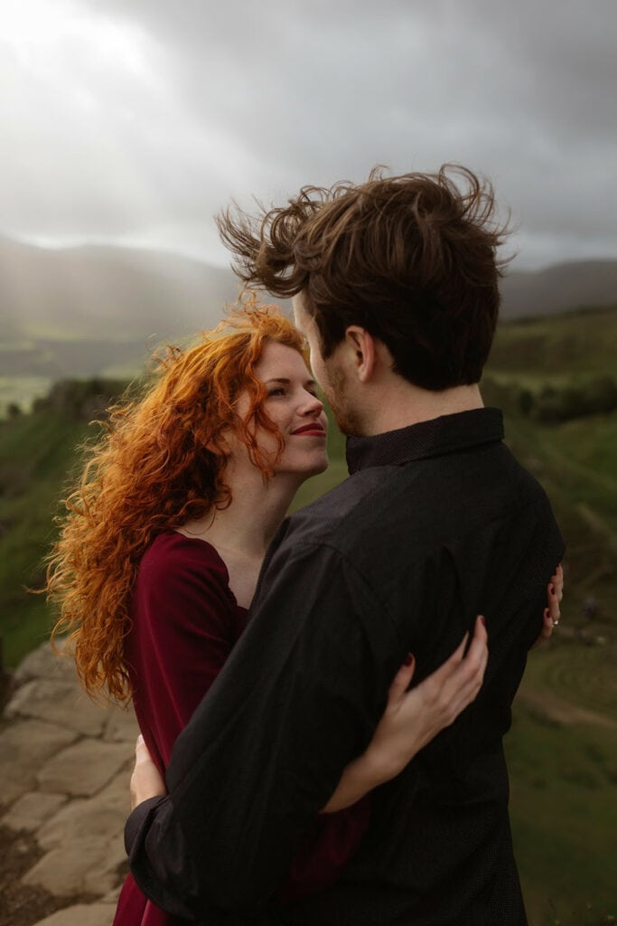 Ashley and Bobby share a beautiful moment as they smile brightly in the Isle of Skye, enjoying the breathtaking scenery and their special time together.